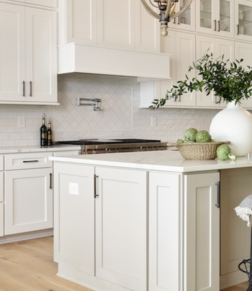 luxury vinyl in kitchen with blue kitchen island and marble backsplash